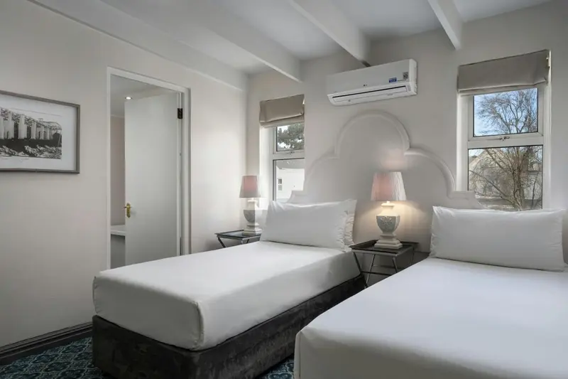 Une chambre lumineuse avec deux lits simples et une décoration sobre.