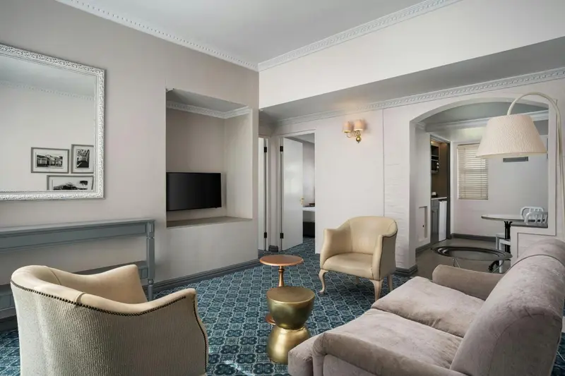 Un salon clair avec deux fauteuils et un canapé.
