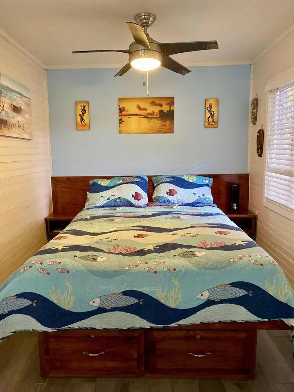 Une chambre avec un grand lit recouvert d'une couette aux motifs marins.