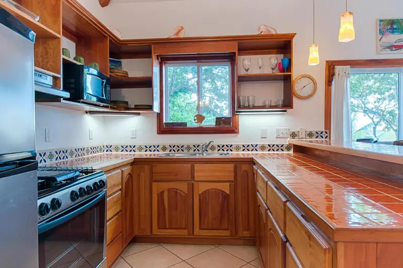 Cuisine lumineuse avec plan de travail en bois et crédence carrelée.