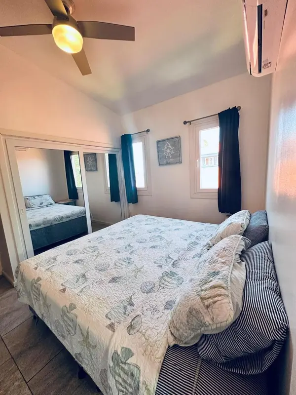 Une chambre lumineuse avec un grand lit recouvert d'une courtepointe à motifs.