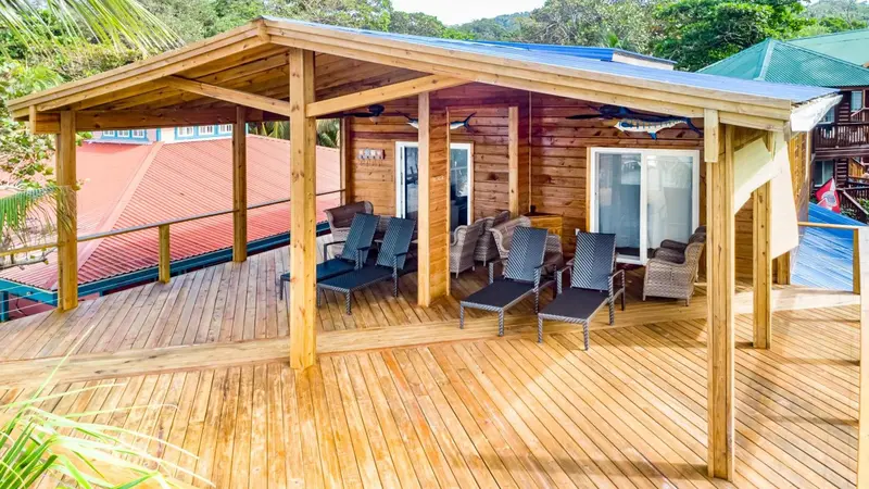 Terrasse en bois avec mobilier de détente et vue sur les bâtiments environnants.