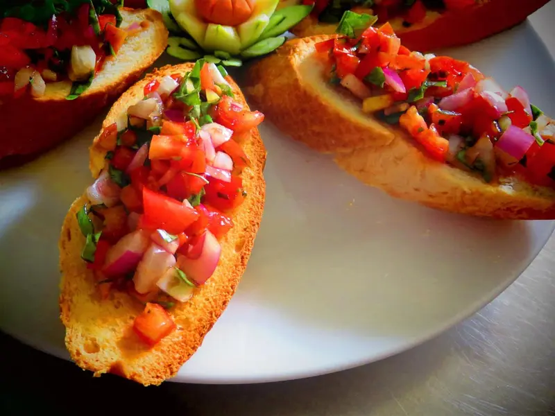 Assiettes de tranches de pain garnies d'une préparation à base de tomates et d'herbes.