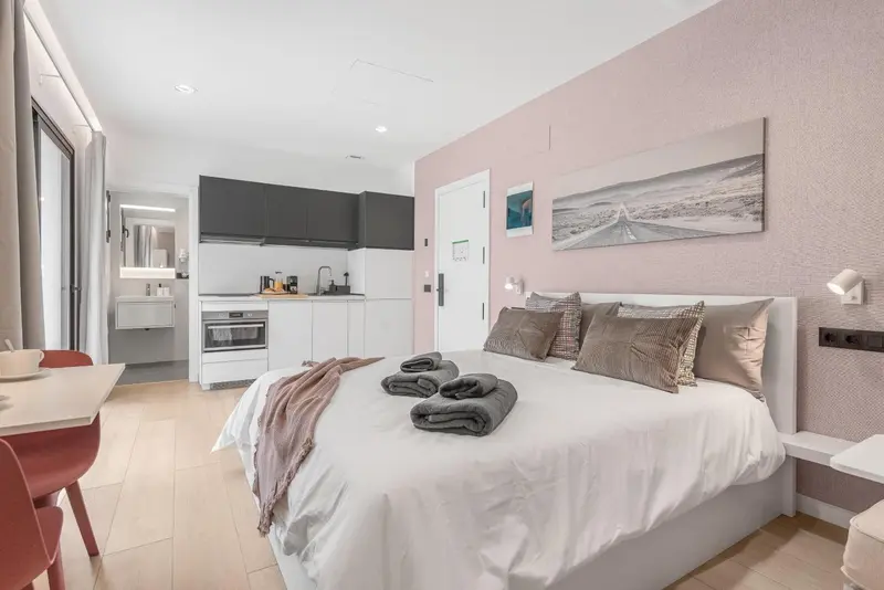 Une chambre avec un lit et une kitchenette.