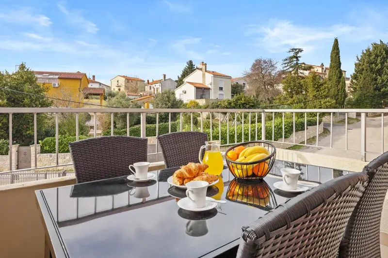 Une table de petit-déjeuner est dressée sur une terrasse avec vue sur un village.