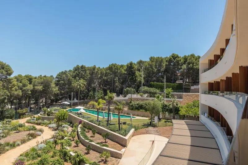 Vue aérienne sur une piscine entourée de végétation et d'une architecture moderne.