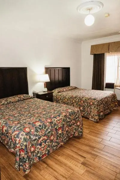 Une chambre avec deux lits recouverts d'une courtepointe à motifs.