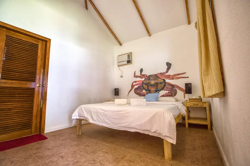 Une chambre lumineuse avec un lit simple et une décoration murale colorée.