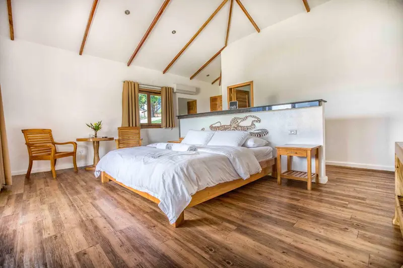 Une chambre lumineuse avec un grand lit et un coin salon.