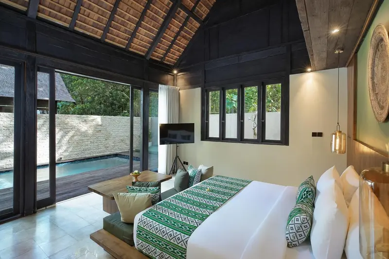 Une chambre lumineuse avec un lit confortable donnant sur une piscine privée.