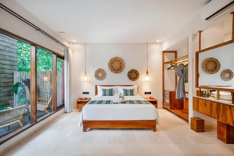 Chambre lumineuse avec un grand lit et une décoration sobre.