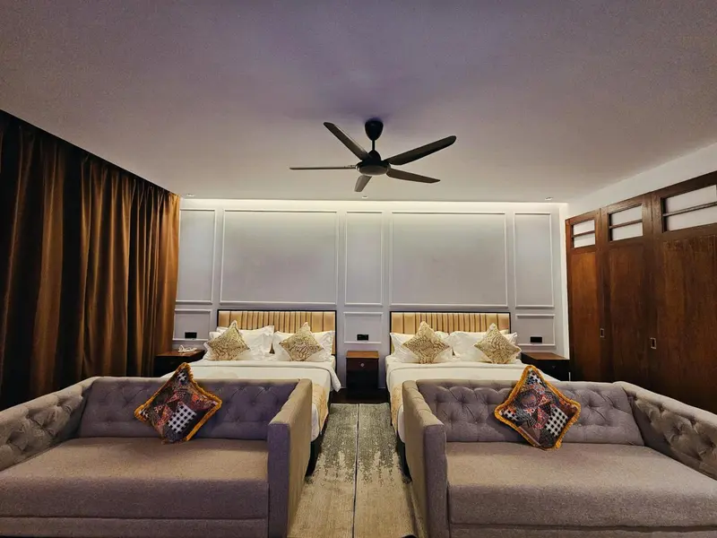Deux lits jumeaux avec des coussins décoratifs dans une chambre lumineuse.