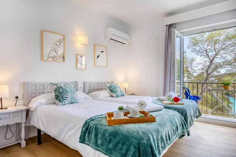 Une chambre lumineuse avec un lit double et un balcon.