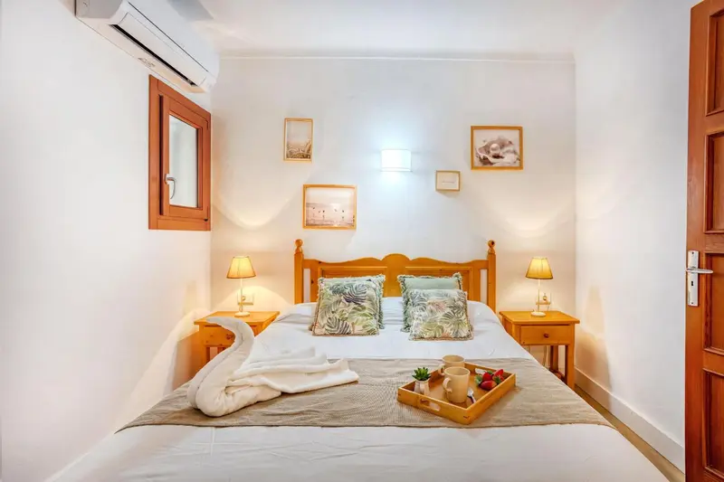 Une chambre lumineuse avec un lit double et des décorations murales.