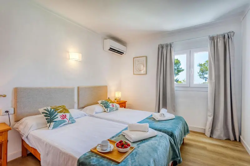 Une chambre lumineuse avec deux lits simples et une décoration florale.
