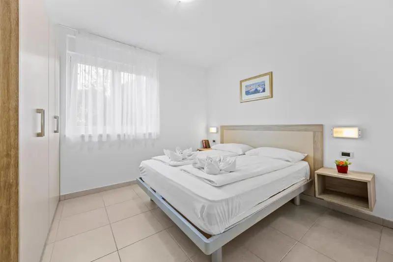 Une chambre lumineuse avec un grand lit recouvert de draps blancs.