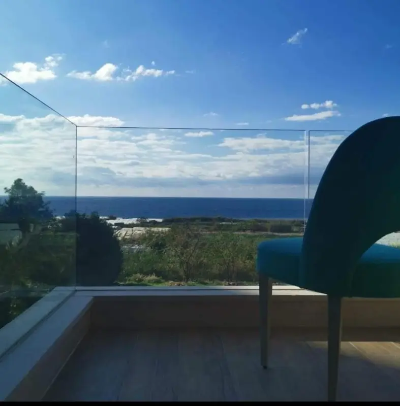 Vue dégagée sur la mer depuis une terrasse ensoleillée.