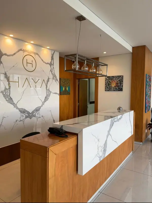 Un comptoir d'accueil moderne avec un mur décoratif en marbre.