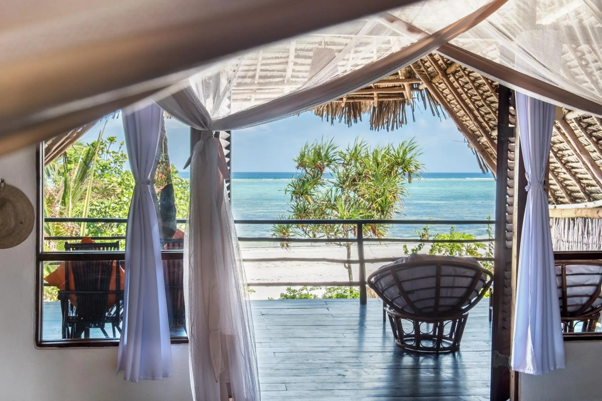 Vue sur la mer depuis une terrasse ombragée.