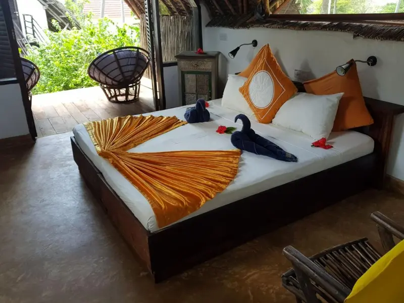 Une chambre lumineuse avec un lit double décoré de fleurs et de serviettes.