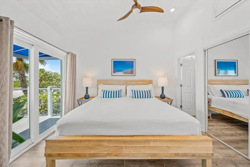 Une chambre lumineuse avec un grand lit et un accès à une terrasse.