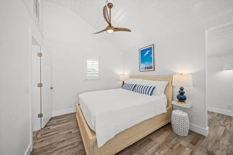 Une chambre lumineuse avec un grand lit recouvert de linge blanc.