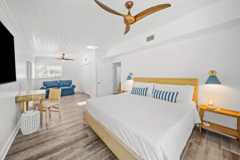 Une chambre lumineuse avec un grand lit et un coin salon.