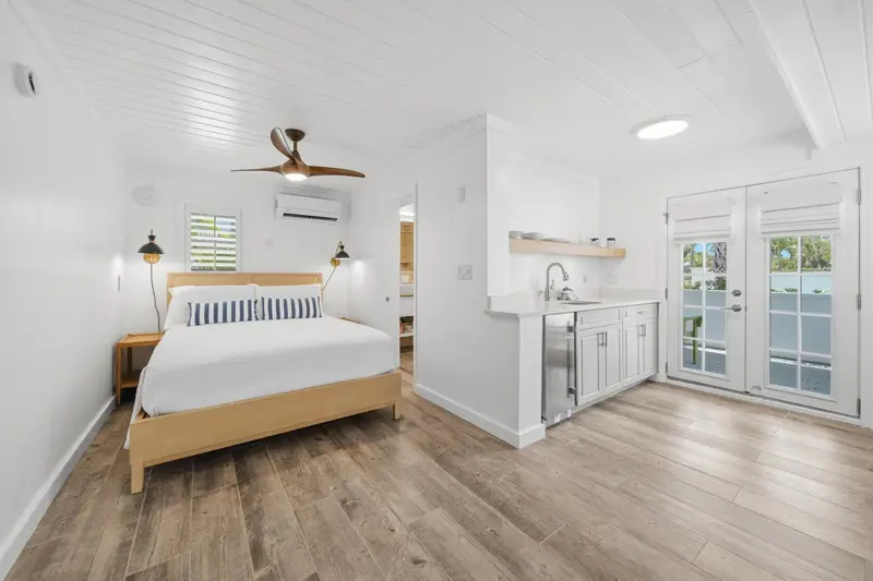 Une chambre lumineuse avec un lit et un coin cuisine.