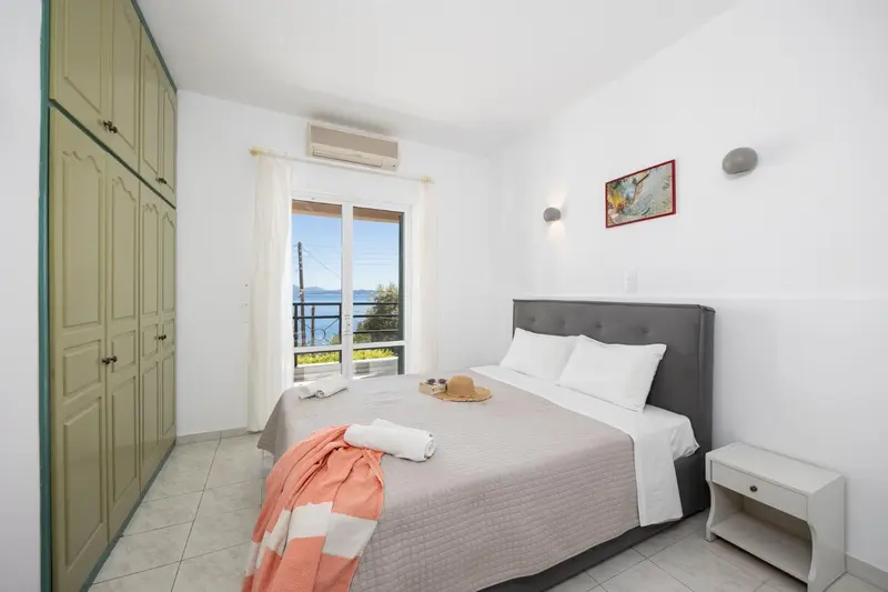 Une chambre lumineuse avec un grand lit et un accès à une vue dégagée.
