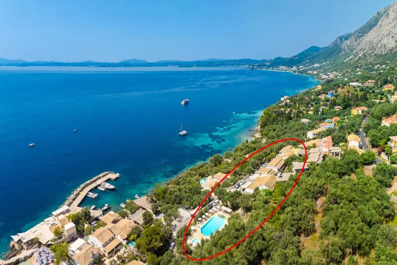 Vue aérienne d'une côte rocheuse avec des bâtiments et une piscine.