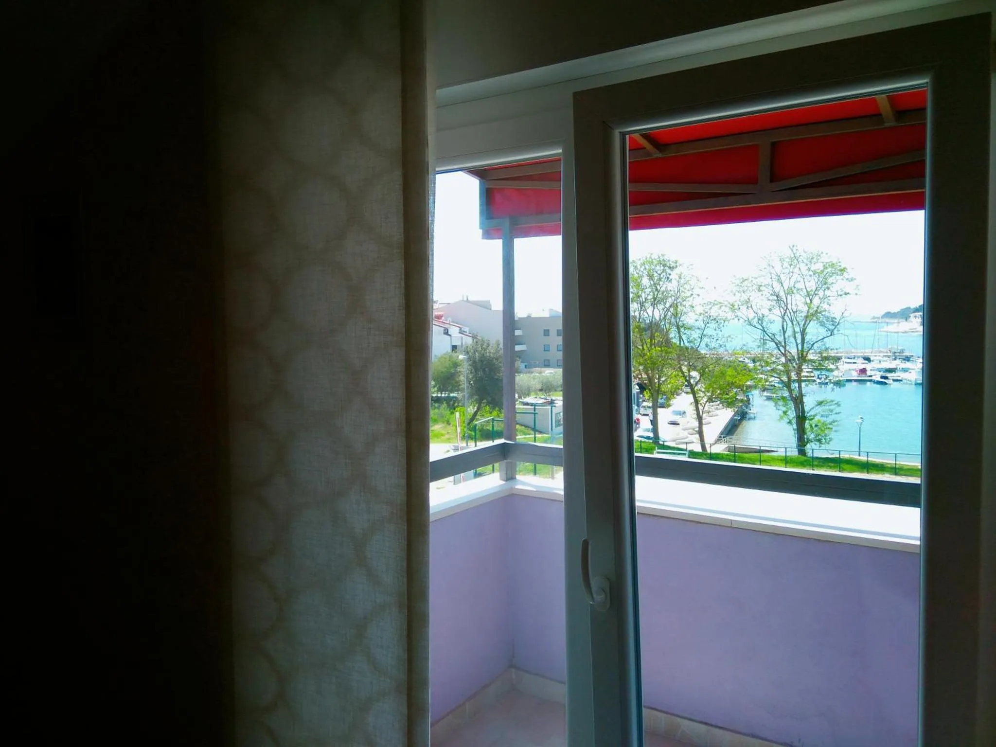 Vue sur la mer depuis un balcon ombragé.