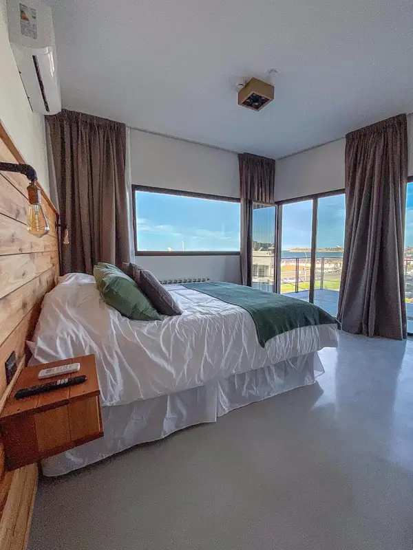 Une chambre lumineuse avec un grand lit et vue sur la mer.