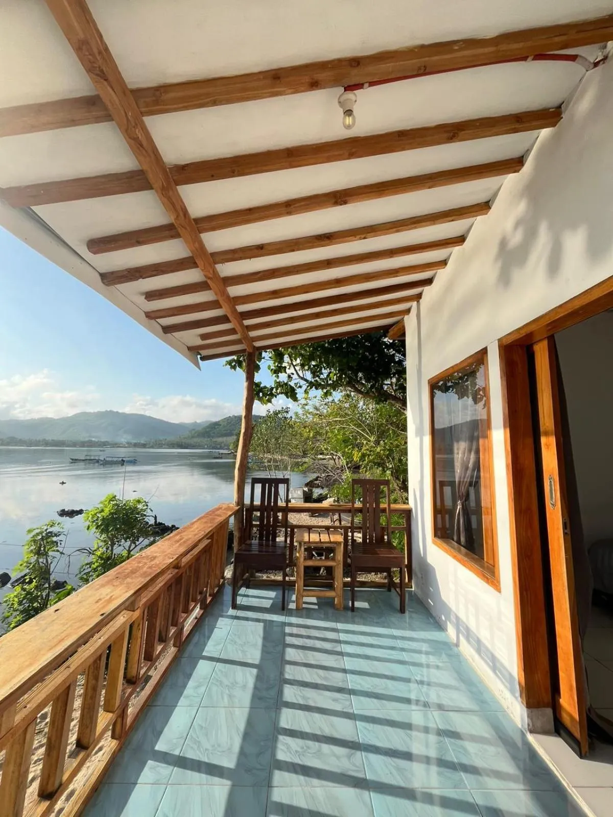 Terrasse ombragée donnant sur la mer et les îles au loin.