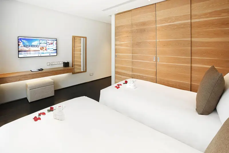 Une chambre lumineuse avec un grand lit et un meuble télévision.