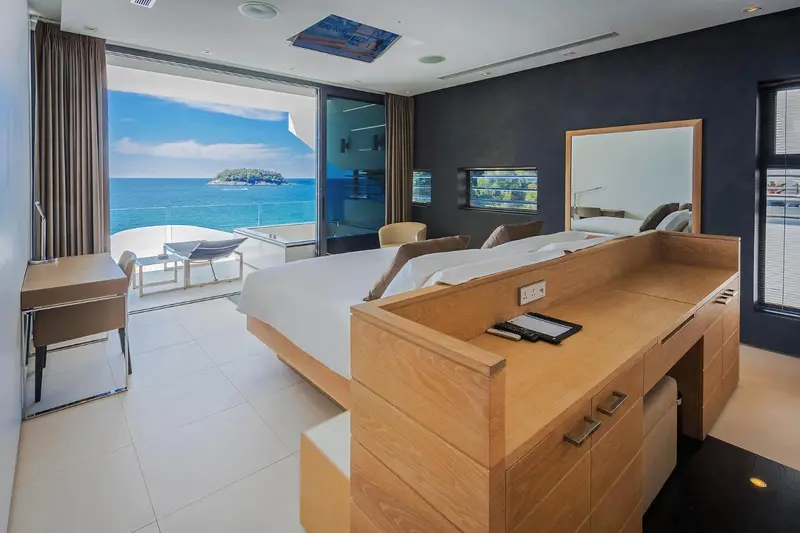 Une chambre lumineuse avec un grand lit et une vue sur la mer.