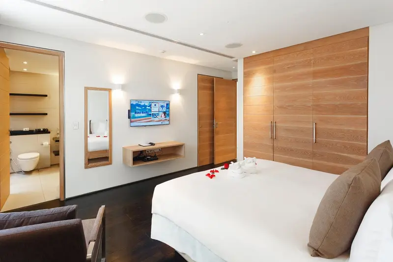 Une chambre lumineuse avec un grand lit et un accès à une salle de bain.