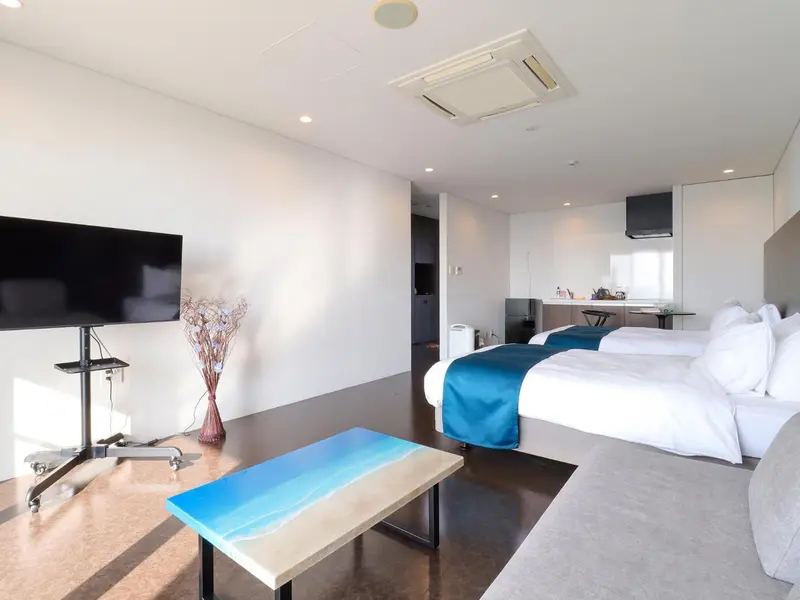 Une chambre lumineuse avec un lit double et un espace salon.