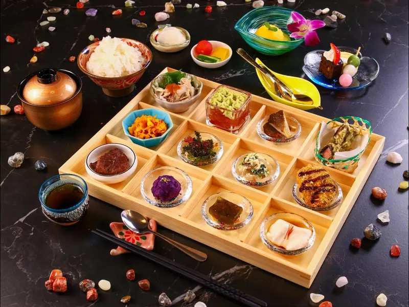 Assortiment de petits plats colorés présentés sur un plateau en bois.