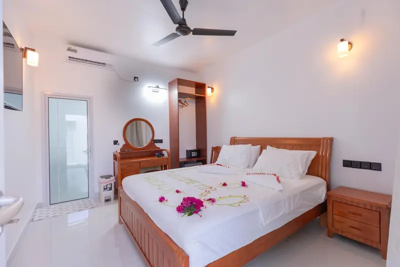 Une chambre lumineuse avec un grand lit décoré de fleurs.