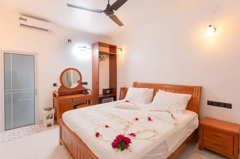 Une chambre lumineuse avec un grand lit décoré de fleurs.