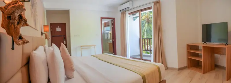 Une chambre lumineuse avec un grand lit et un accès à une terrasse.
