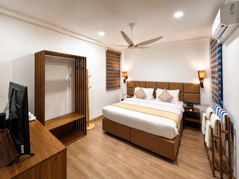 Une chambre lumineuse avec un grand lit et un espace bureau.