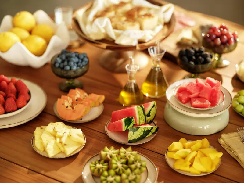 Une table en bois est garnie de salades de fruits frais et colorés.
