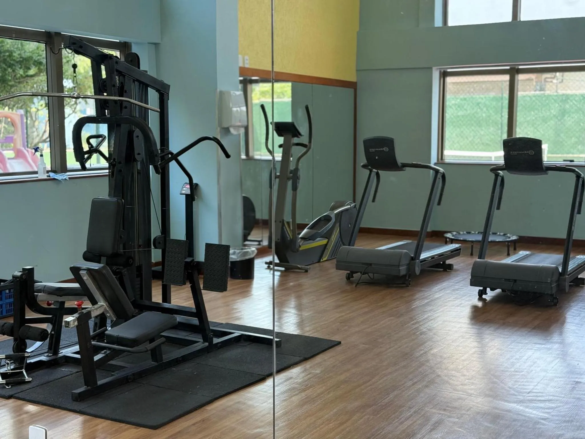 Une salle de sport lumineuse avec des équipements de musculation et cardiovasculaire.