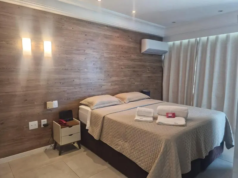 Une chambre lumineuse avec un grand lit et une décoration sobre.