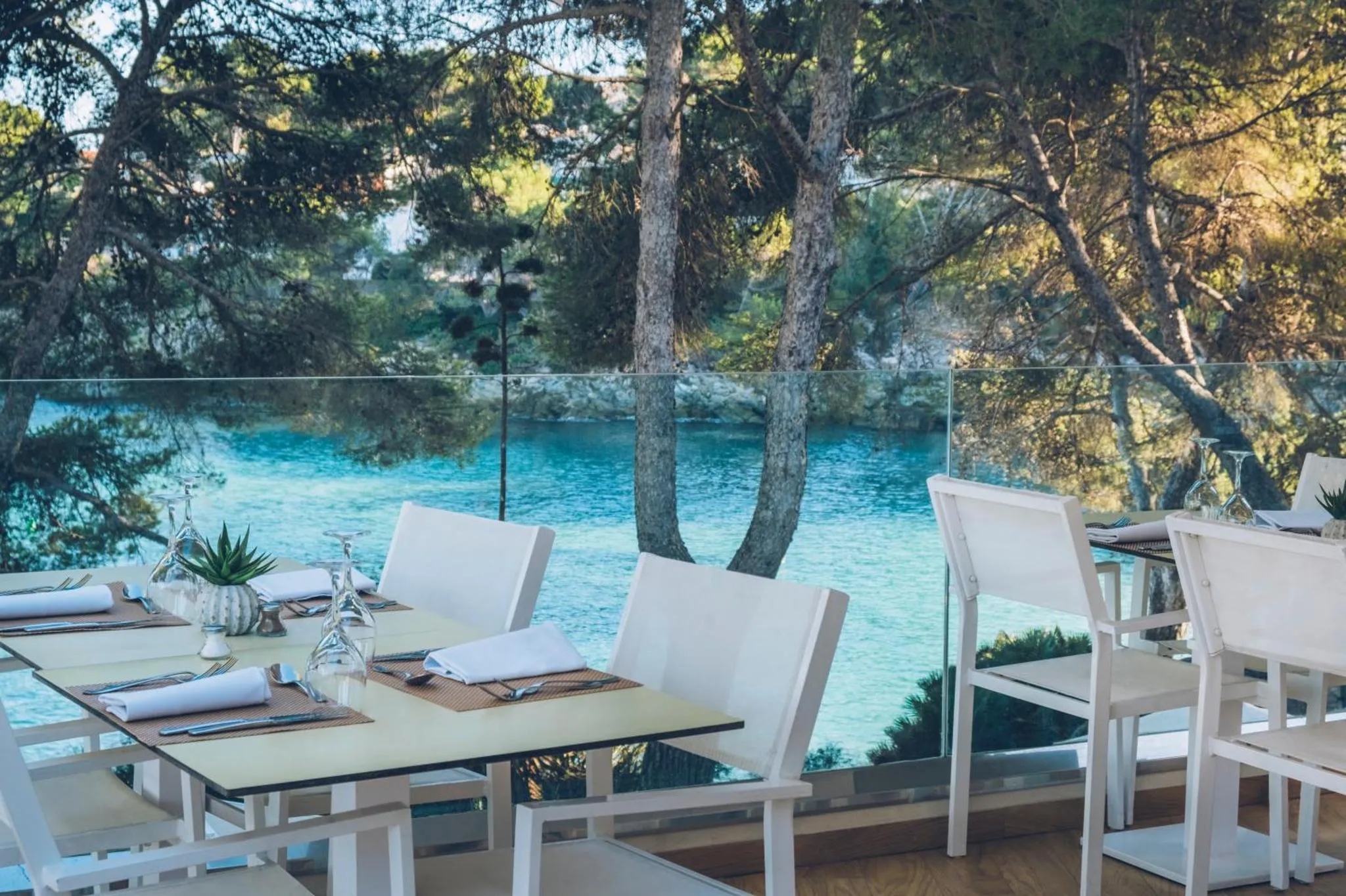 Tables dressées en terrasse avec vue sur la mer.