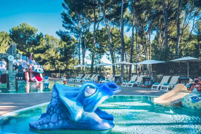 Piscine pour enfants avec toboggan et structure en forme de grenouille.