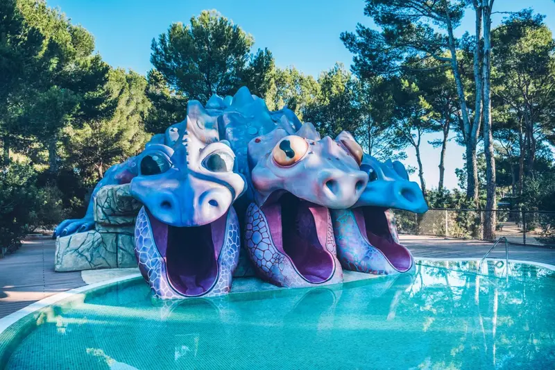 Une piscine pour enfants avec une sculpture de serpent de mer colorée.