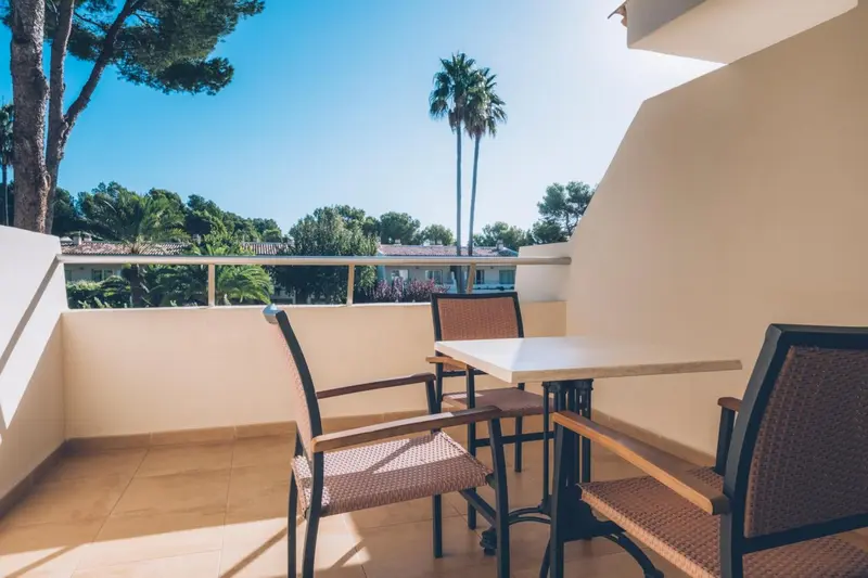 Terrasse avec mobilier en osier et vue sur la végétation.