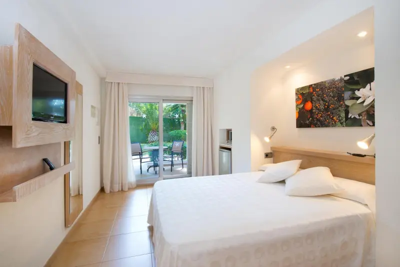 Une chambre lumineuse avec un grand lit et un accès à une terrasse.